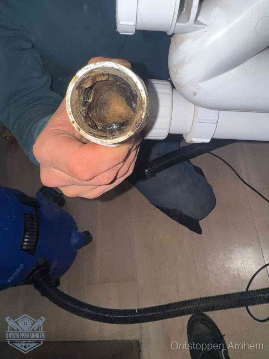 Een losgekoppeld afvoerbuisstuk dat van binnen volledig is dichtgeslibd, het gevolg van een verstopping te lang laten zitten in Arnhem
