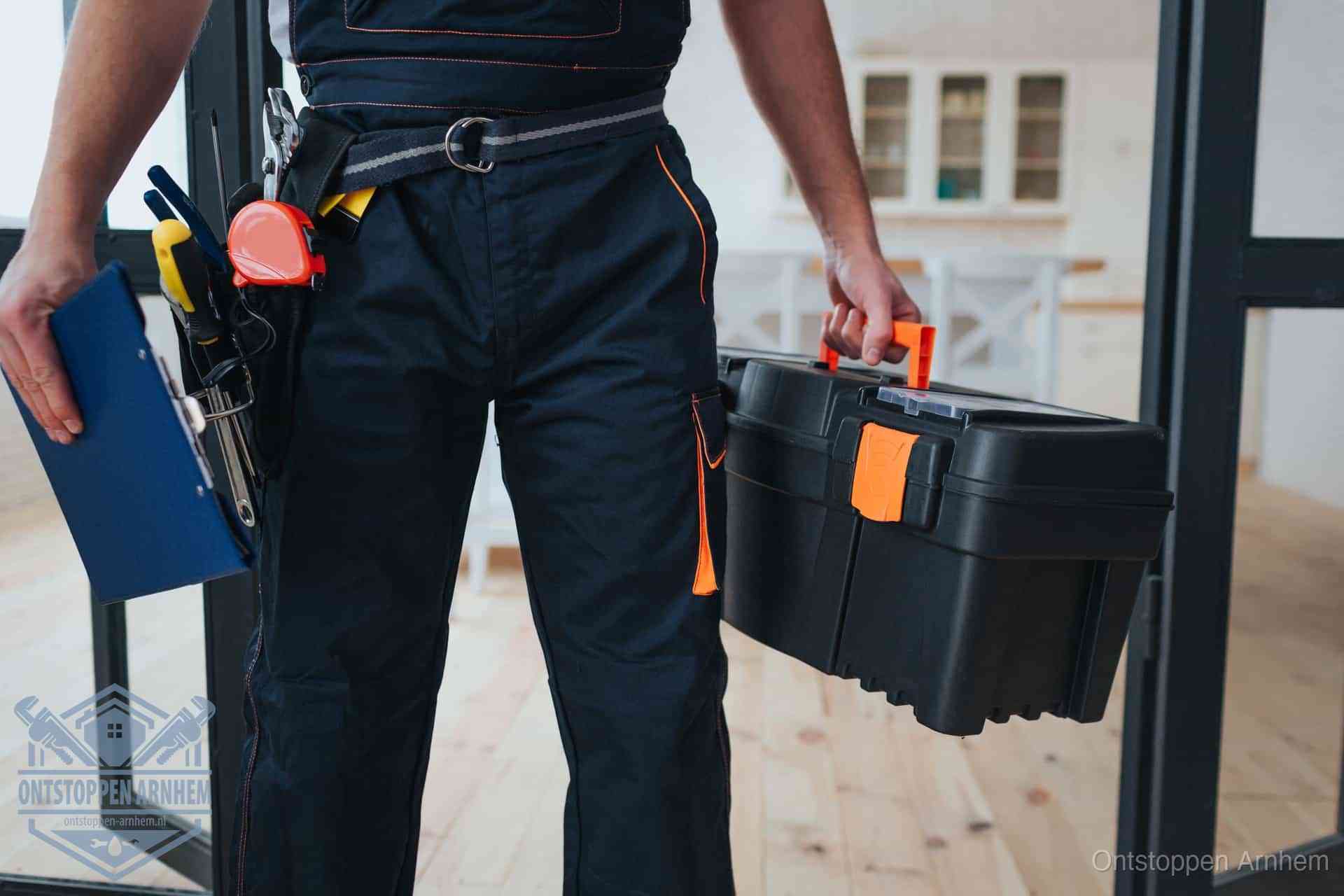 Een monteur met gereedschapsriem en klembord, klaar om een transparante prijs voor het wc ontstoppen in Arnhem te geven