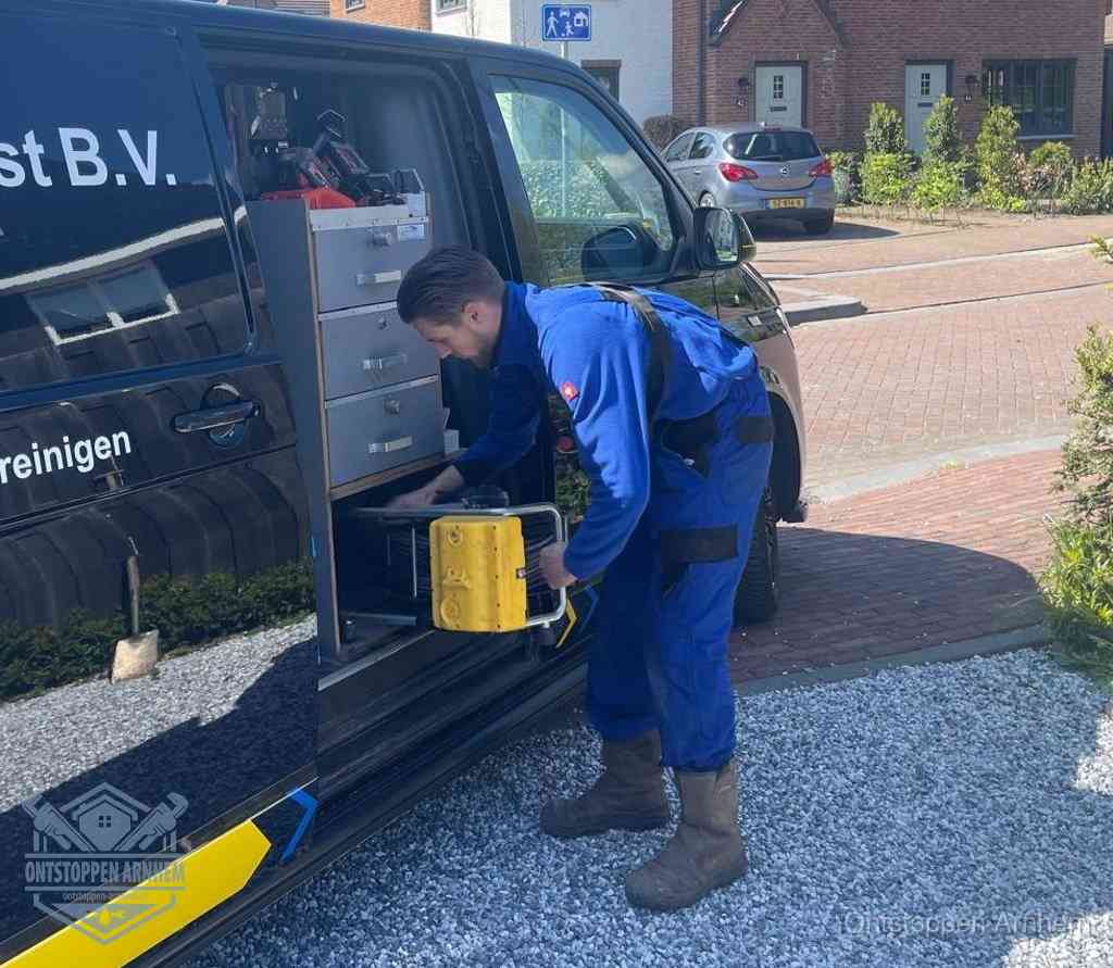 Een monteur pakt apparatuur uit de bedrijfsbus voor service aan huis, het moment om een professional in te schakelen voor een verstopte wc in Arnhem
