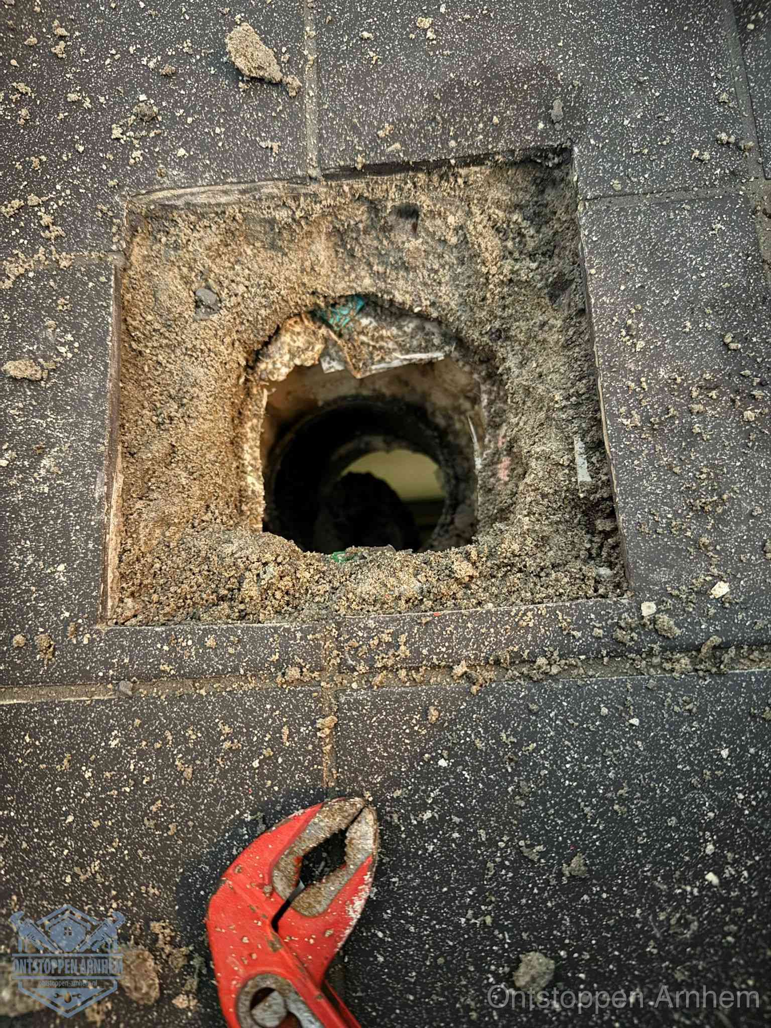 Geopend rioolputje op de erfgrens dat laat zien wie eigenaar is van de riolering in Arnhem