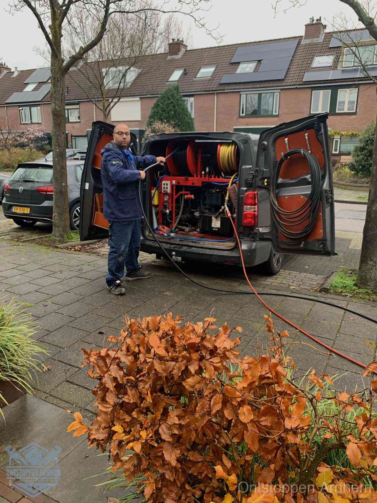 Monteur met rioolreinigingsbus levert rioolservice in de wijk in Arnhem