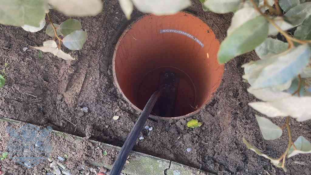 Open inspectieput in de tuin waar een veer rioolvliegjes en stankoverlast aanpakt in Arnhem